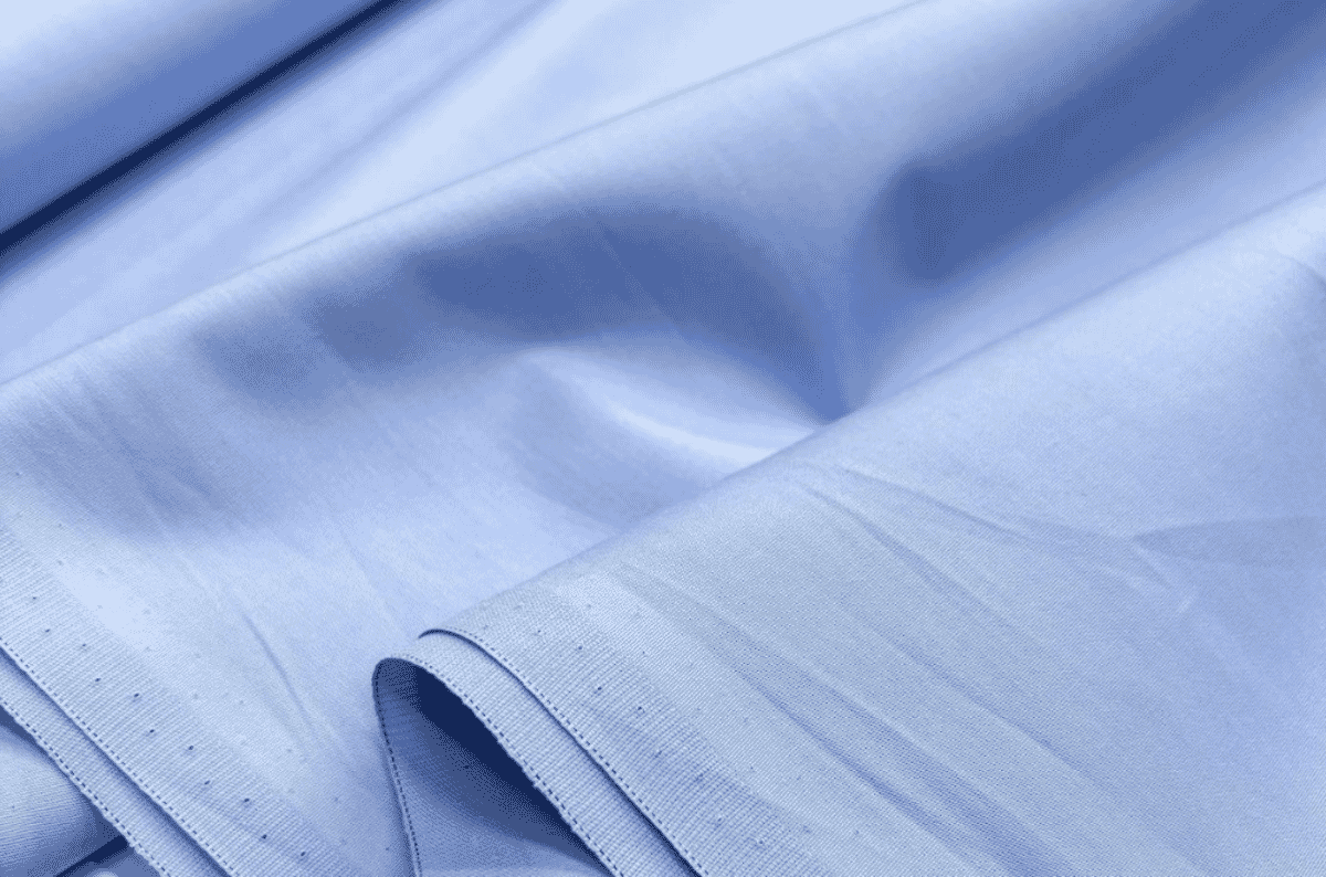 Close-up of crisp cotton poplin fabric with a smooth face and subtle horizontal rib, the fine plain-weave construction used for dress shirts and blouses.