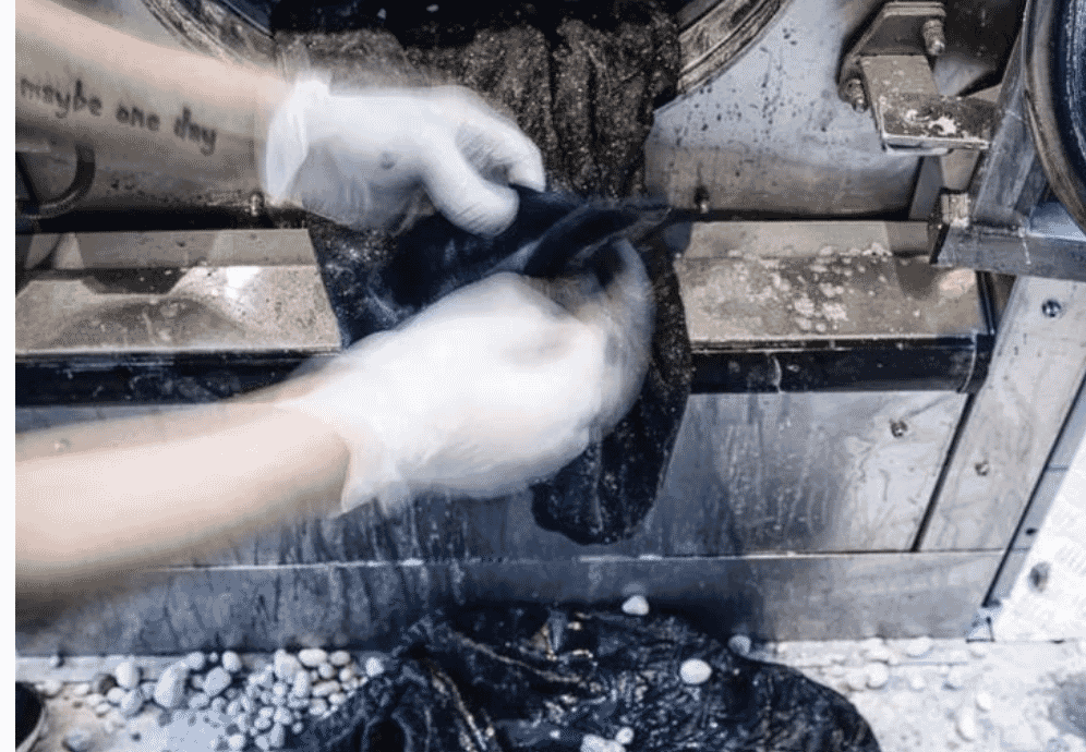 Ozone-washed denim showing an even fade produced by gas-phase oxidation with minimal water use at a Portuguese wash house.