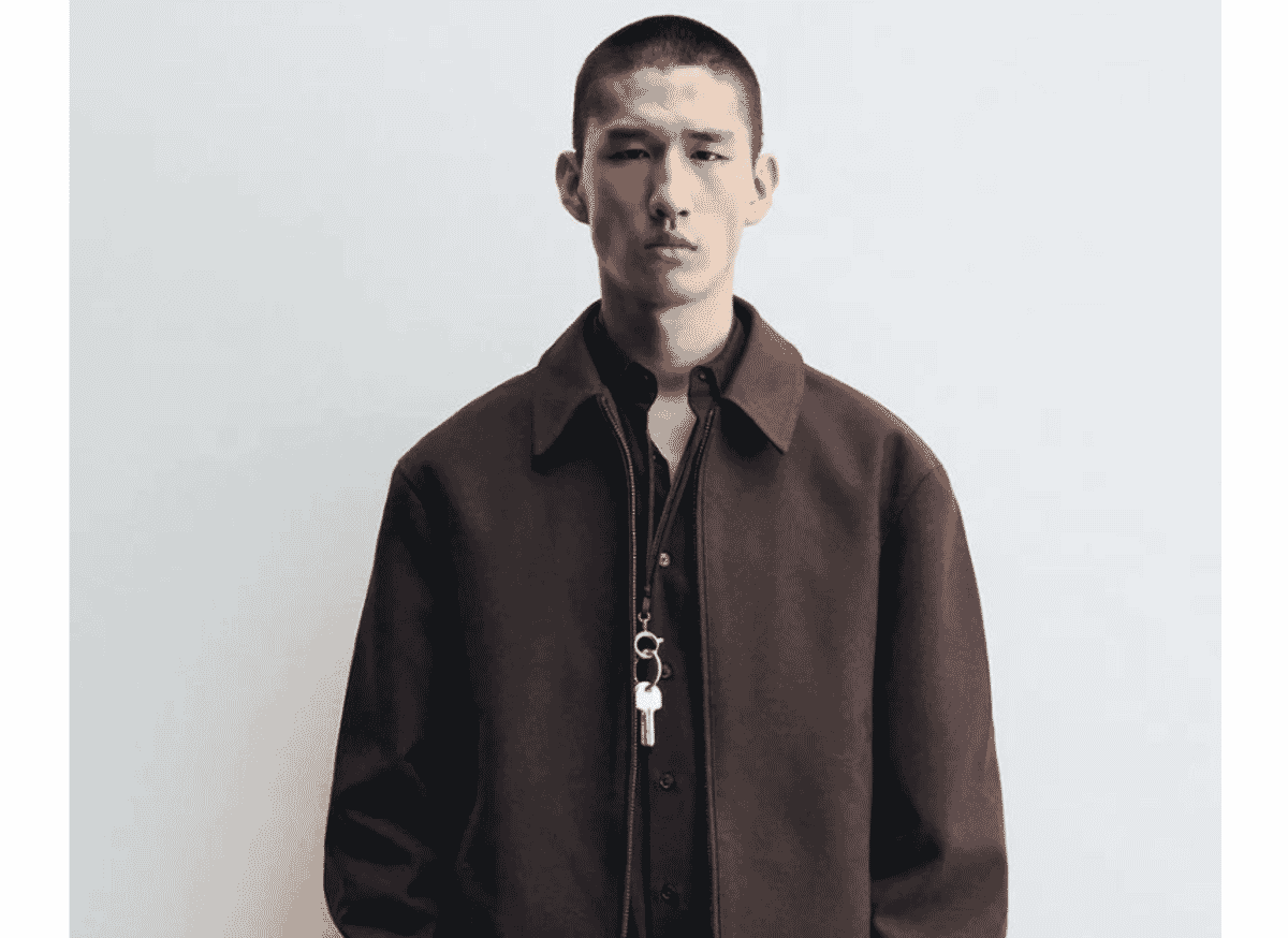 A dark brown twill zip-front jacket with a flat collar, worn over a shirt.