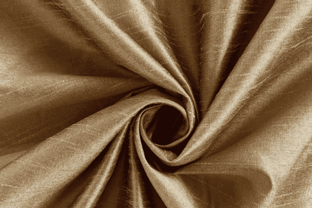 Dupioni de seda com textura slub característica, usado em vestidos estruturados e casacos.