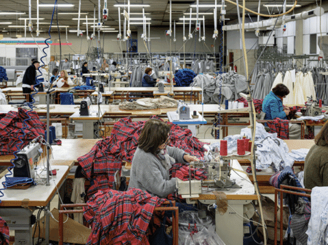 Operators sewing flannel shirts on a production line