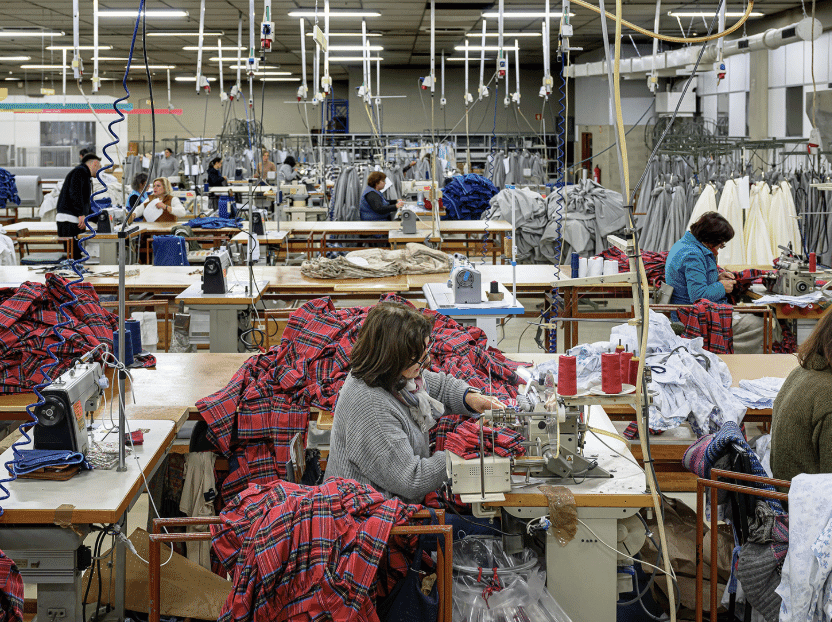 Operators sewing flannel shirts on a production line