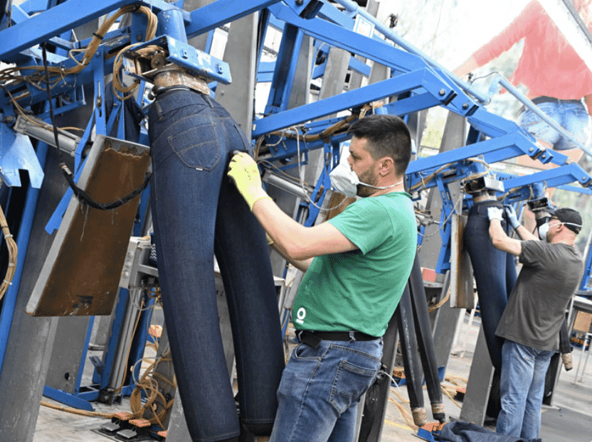 Workers finishing jeans on inflatable forms