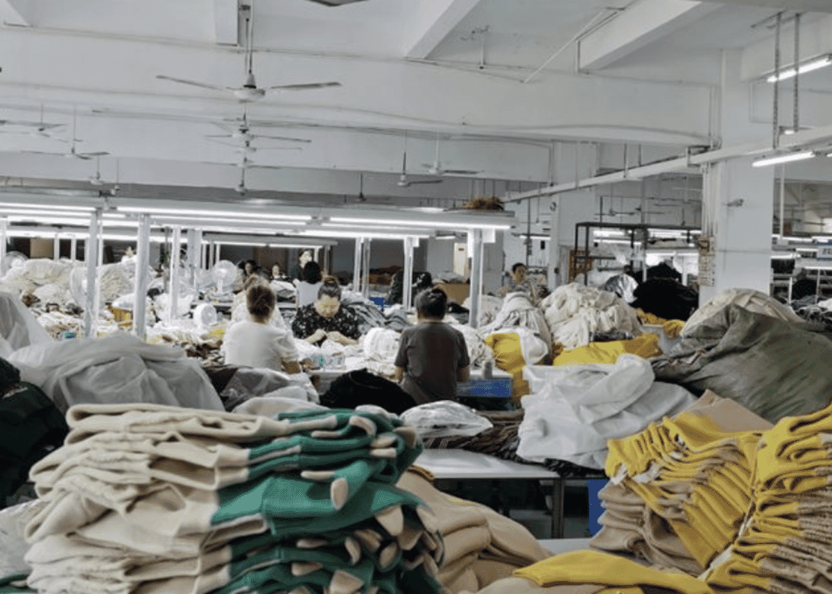 Garment workroom with stacks of knitted pieces waiting to be sewn