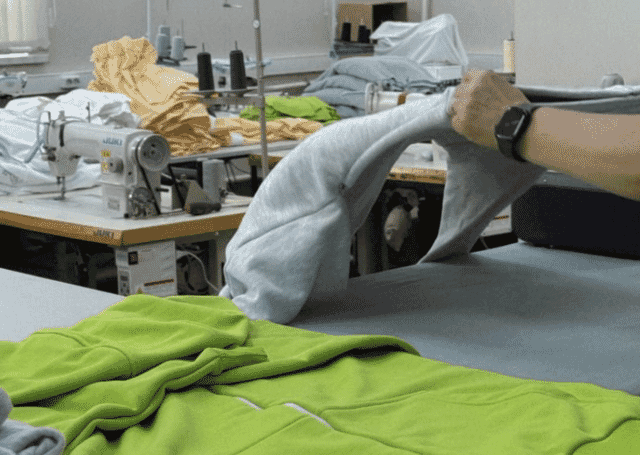 Handling fleece at the sewing table in a garment factory